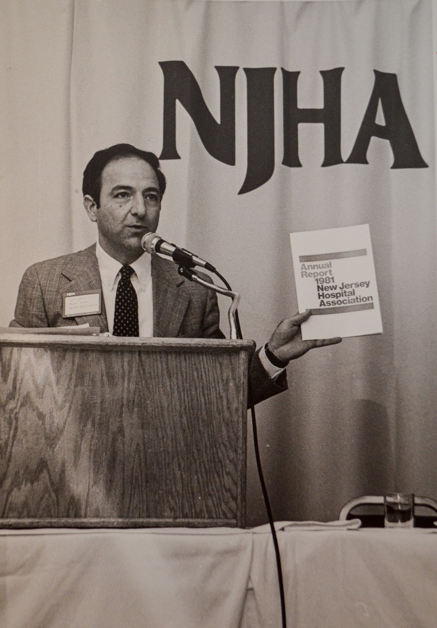 NJHA President and CEO Lou Scibetta holds up a copy of the 1981 annual report for the Association.