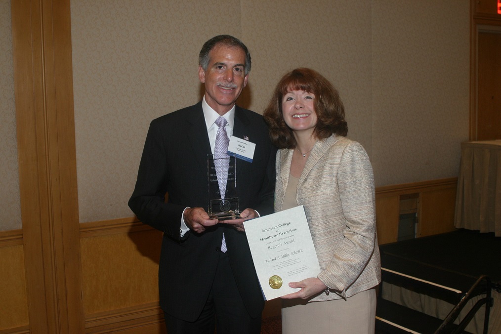 Richard P. Miller, president and CEO of Viruta, receives an award from Adrienne Kirby, then-COO of Virtua, now CEO of Cooper University Health Care, at the annual American College of Healthcare Executives breakfast in 2004.