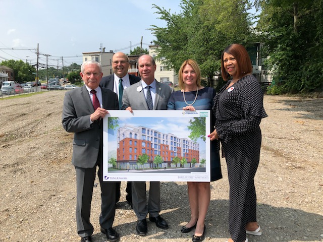 Cathy Bennett and group holding up design of the Barclay Street apartment building for supportive housing.