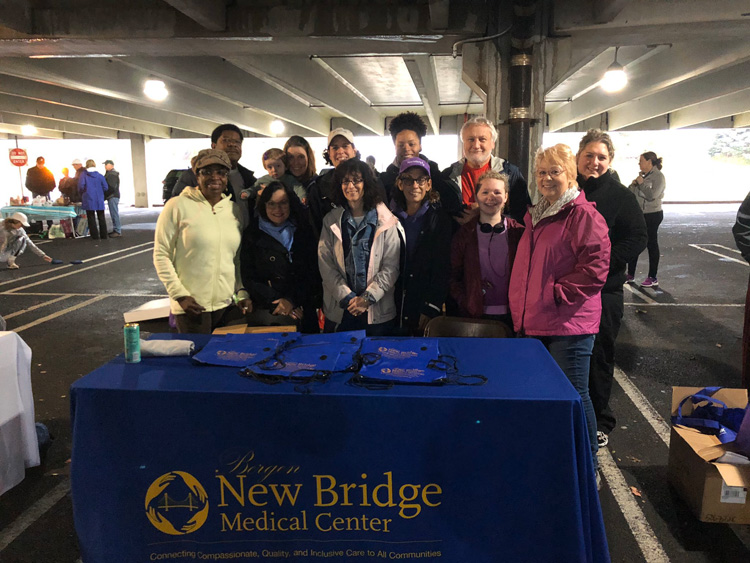 Group of New Bridge Medical Center employees posing behind table for Alzheimer Walk.