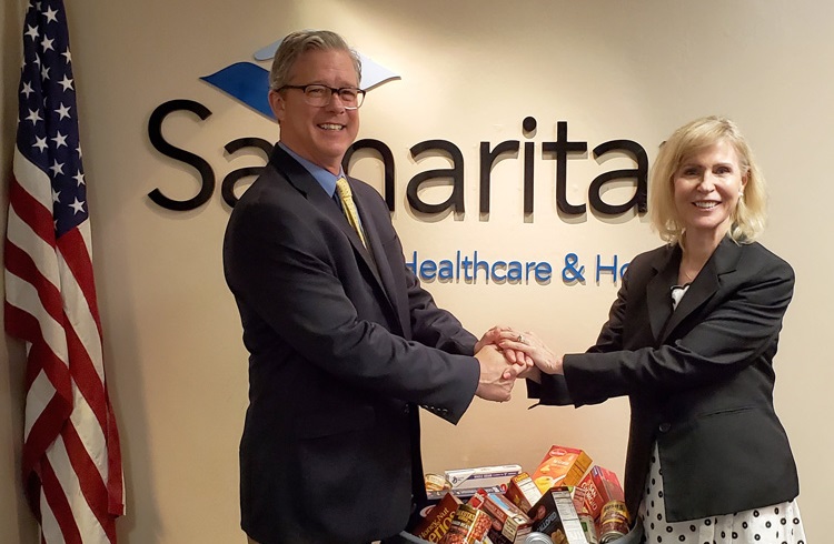 Food Bank of South Jersey President Fred Wasiak (left) and Samaritan Healthcare & Hospice President and CEO Mary Ann Boccolini (right) standing by collected food items.