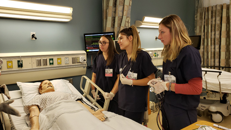 Group of nurses training with a patient mannequin.