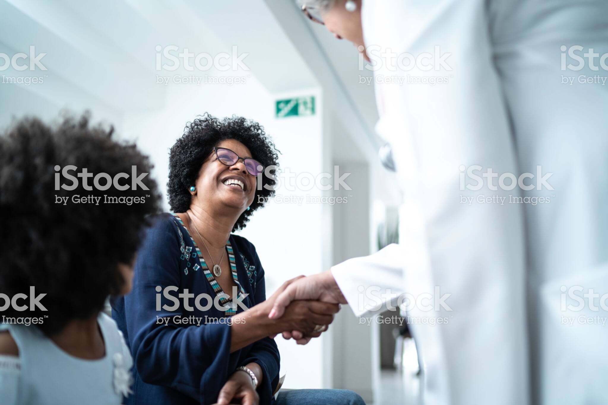 Woman shaking hands with a female doctor.