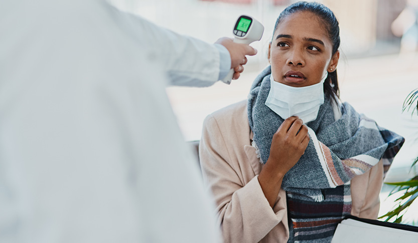 Female patient getting temperature checked by doctor.