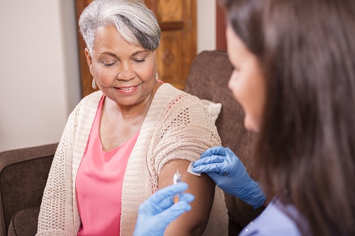 Doctor giving a female senior citizen a shot.