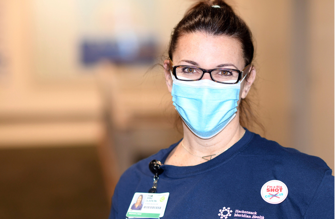 Female healthcare worker wearing a I'm a Big Shot sticker.