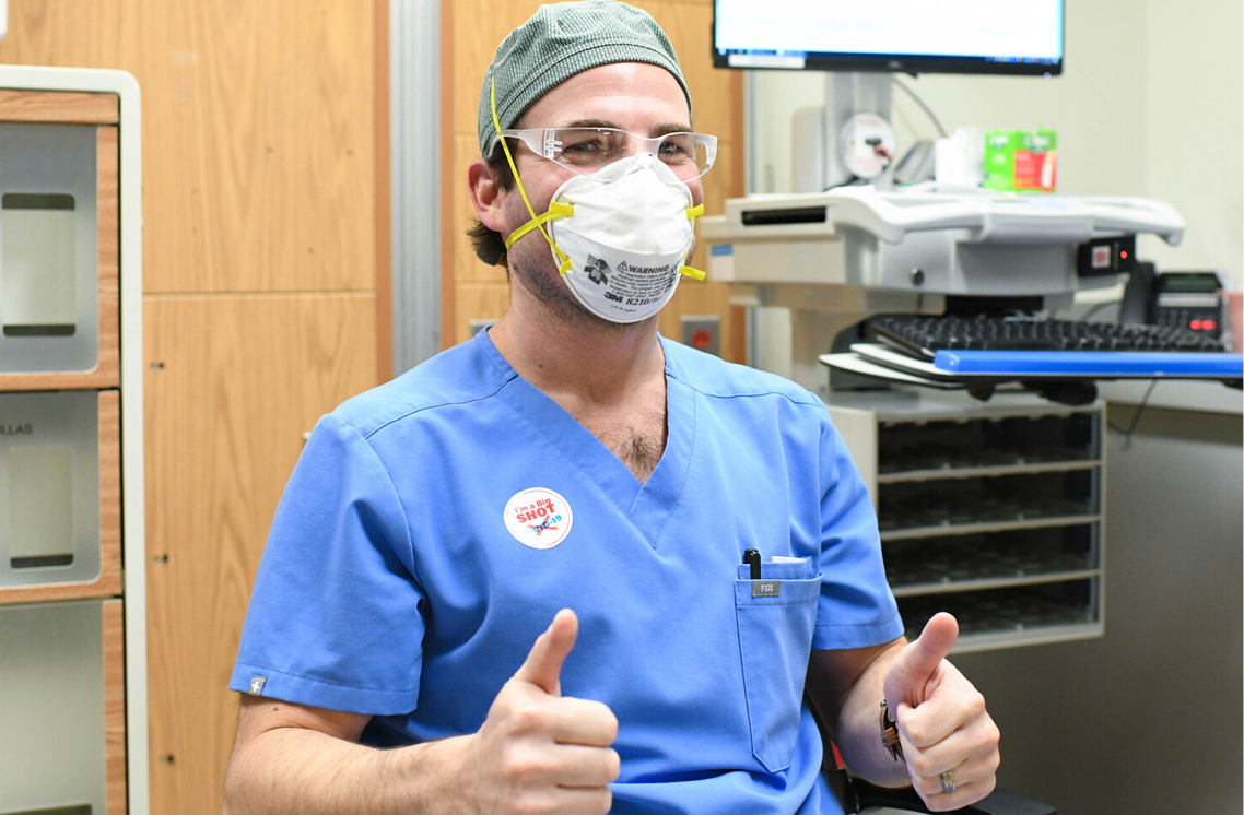 Male healthcare worker wearing a I'm a Big Shot sticker.