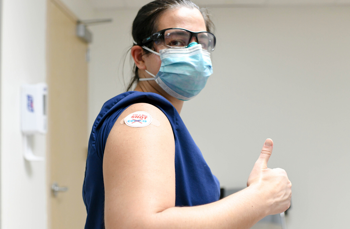 Male healthcare worker wearing a I'm a Big Shot sticker.