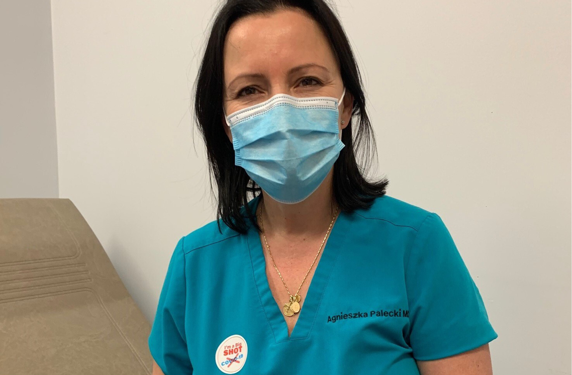 Female healthcare worker wearing a I'm a Big Shot sticker.