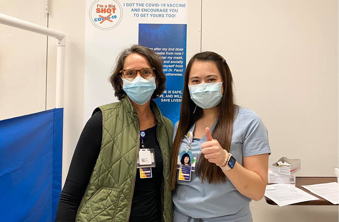 Two female healthcare workers standing below a I'm a Big Shot sticker.