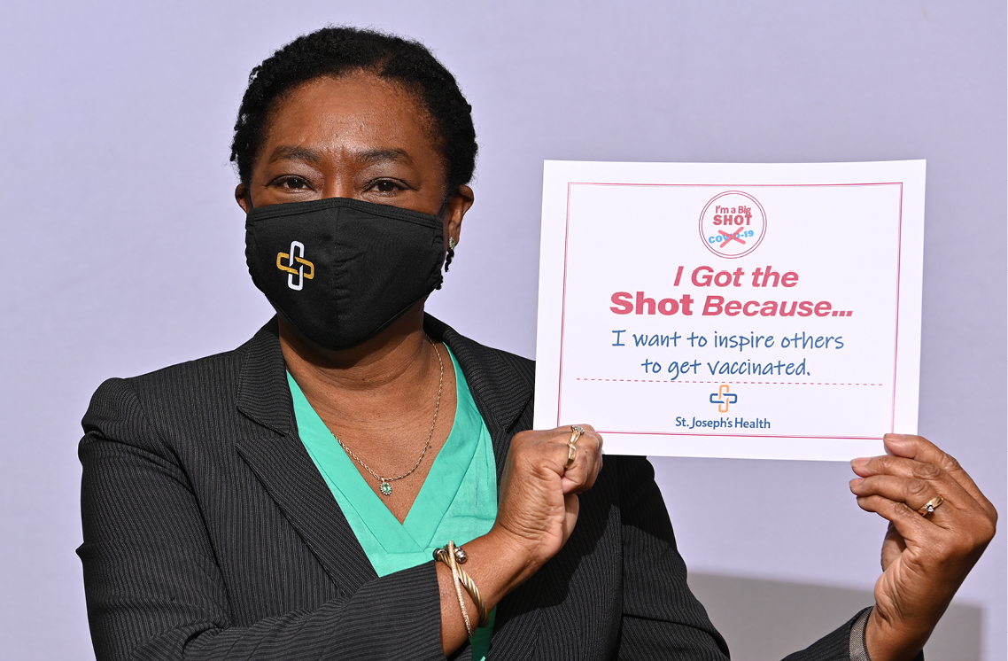 Female healthcare worker holding a I'm Got the Shot sign.