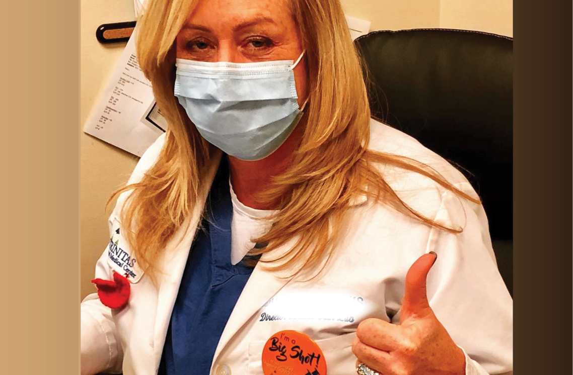 Female healthcare worker wearing a I'm a Big Shot sticker.