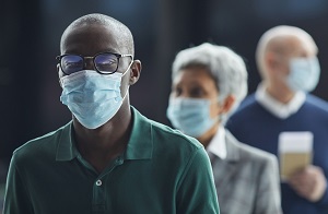 People waiting in line wearing masks.