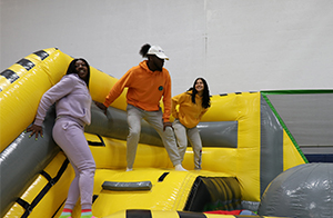 Students playing in a blow up jungle gym.