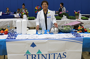 Trinitas representative standing behind table.