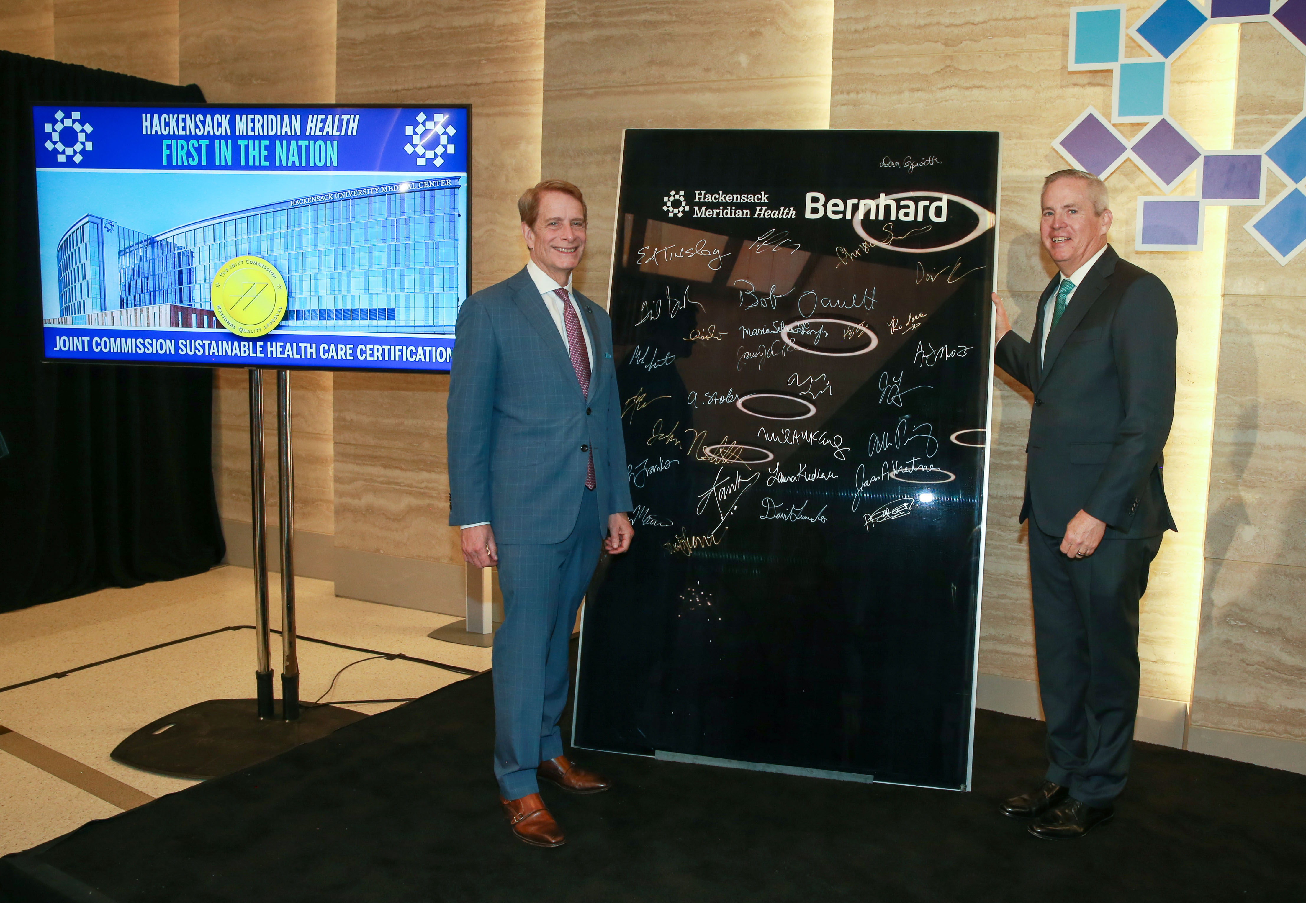 Global Citizenship features an image of Hackensack Meridian Health staff standing on either side of a tall informational board. To the left is a monitor screen on a stand with the words Hackensack Meridian Health First in the Nation on it